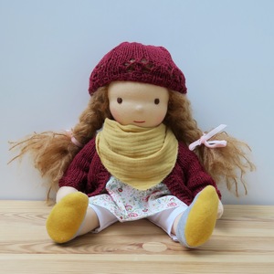 Handgemachte Waldorfpuppe mit goldblonden Haare und rote Strickjacke